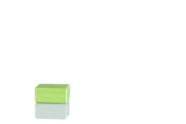 Wooden cube of green color on a white background close up