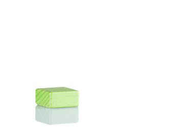 Wooden cube of green color on a white background close up