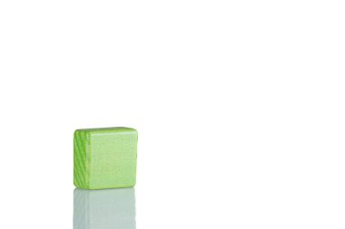 Wooden cube of green color on a white background close up