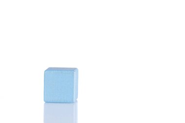 Wooden cube of blue color on a white background close-up