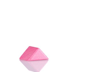 Wooden triangle of pink color on a white background close-up