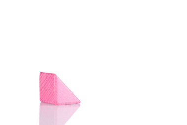 Wooden triangle of pink color on a white background close-up