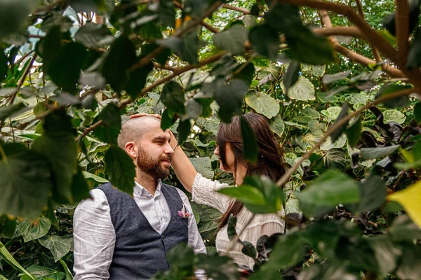 beautiful couple girl and guy in the park among tropical trees close-up