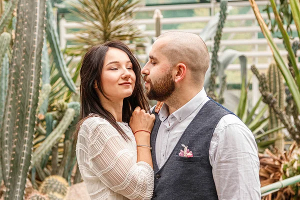 beautiful couple girl and guy in the park among tropical trees close-up