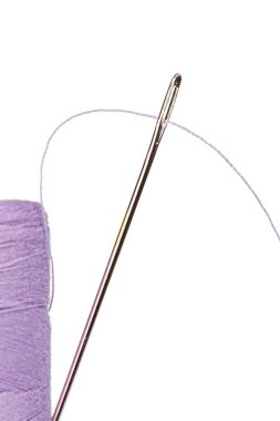 Beyaz arka plan üzerinde bir iğne ile iplik mor renkleri makro skein yakın plan