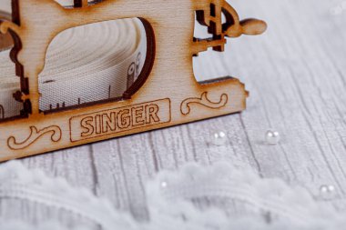 Dikiş bandı, dikiş makinesi ve ahşap manken yakın plan.