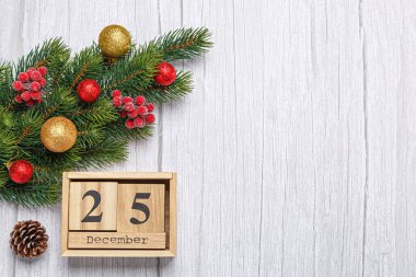 Oyuncak ve hediyelerle Noel ağacı dalı ve tahta takvim 25 Aralık ahşap arka planda yakın plan