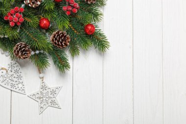 Noel kompozisyonu, oyuncaklı Noel ağacı dalı, ahşap arka planda koniler.