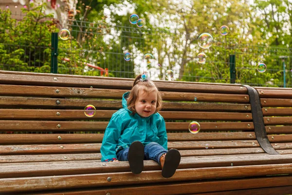 Portrait Little Girl Park Bench Catches Soap Bubbles Close — Stockfoto