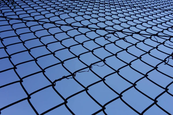 背景是仲夏的蓝天 铁丝网绕着棒球场伸展着 — 图库照片