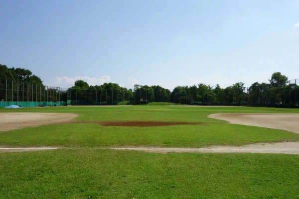 八月的仲夏蓝天 一张静谧的风景照片 是棒球场上下午烈日下的地面 — 图库照片