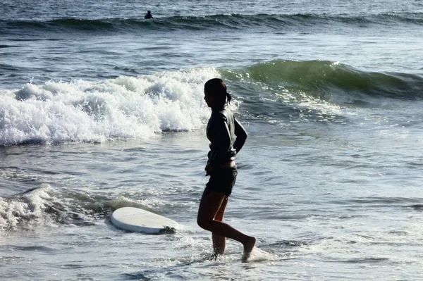 Lifestyle of a young woman surfing waves on the beach in secret, surfboard