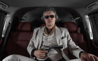 Beyaz takım elbiseli adam silahlı, çete üyesi, arabada mafya.