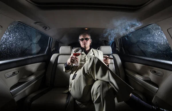 A rich man in a white suit and a cigar in the car, a limousine