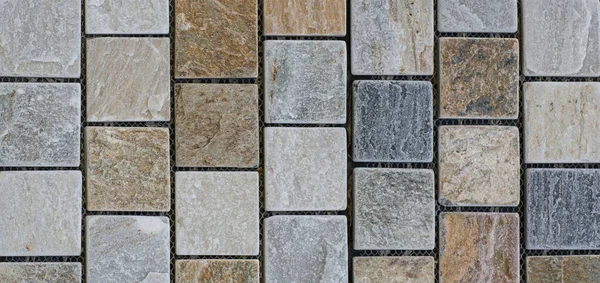 Abstract, geometric, tiled pattern of solid stone