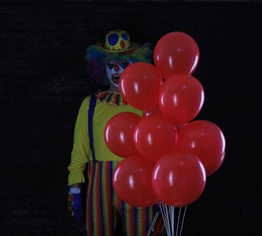 Kırmızı balonlu kötü palyaço.