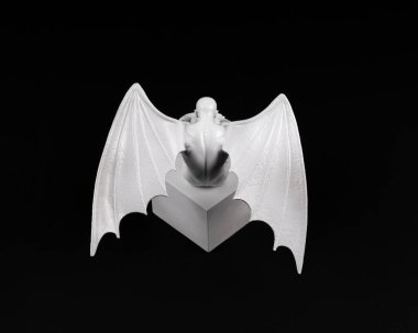 Siyah arka planda kanatları olan beyaz üzgün melek.