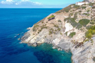Elba 'nın kayalık kıyılarından mavi denize bak.