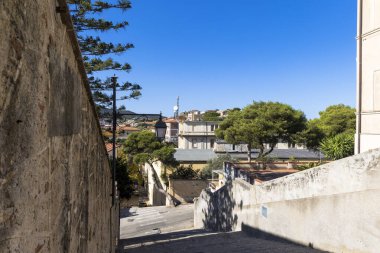 İtalya 'nın Elba adasında bulunan ada başkenti Portoferraio' da tipik İtalyan evlerinin bulunduğu sokak yazın açık mavi gökyüzünün altında.