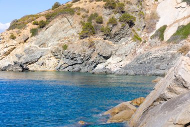 Elba 'nın kayalık kıyılarından mavi denize bak.