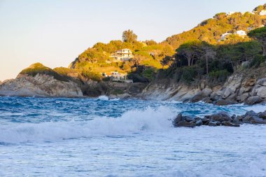 İtalya 'nın Elba adasında, Sant' Andrea yakınlarındaki sahil ve deniz. Yazın alacakaranlıkta mavi gökyüzü.
