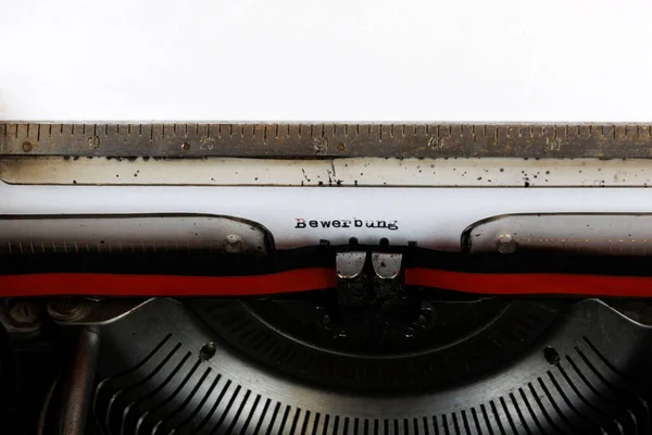 Bewerbung 一词用红色写在一台旧的机械打字机上 — 图库照片