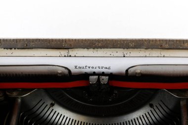 Almanca Kaufvertrag kelimesi eski bir mekanik daktilo Almanca metni ile yazılmıştır: Satın alma sözleşmesi