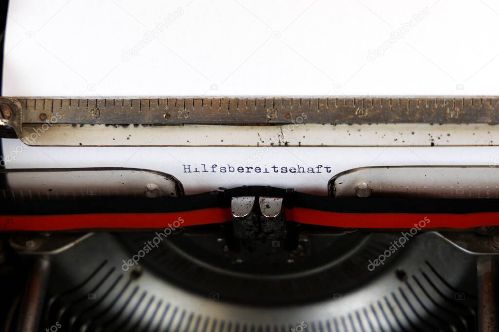 The German word Hilfsbereitschaft written on an old mechanical typewriter German Text: Helpfulness
