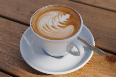 Güzel çizilmiş kremalı beyaz bir fincan espresso.