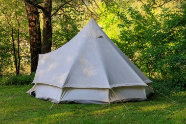 Scout white tent at the edge of the forest in the scout tent camp
