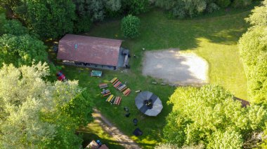 Göl kenarındaki ağaçların arasından yurt çadırlarını kurarken yukarıdan izci kampına bak.