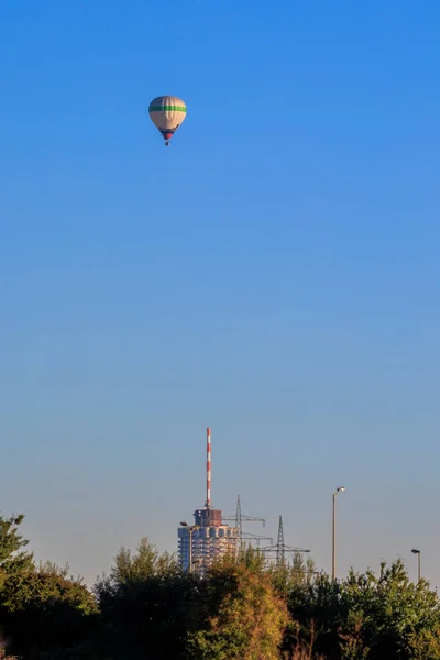 一个五彩缤纷的热气球在奥格斯堡市上空的清晨蓝天里 — 图库照片