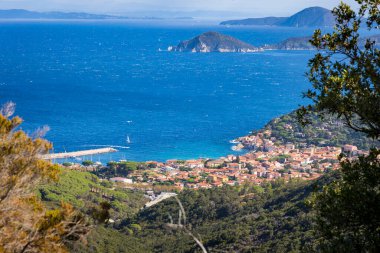 Elba adasının kıyısındaki Marciana Marina 'nın ev ve tepelerine bakın.