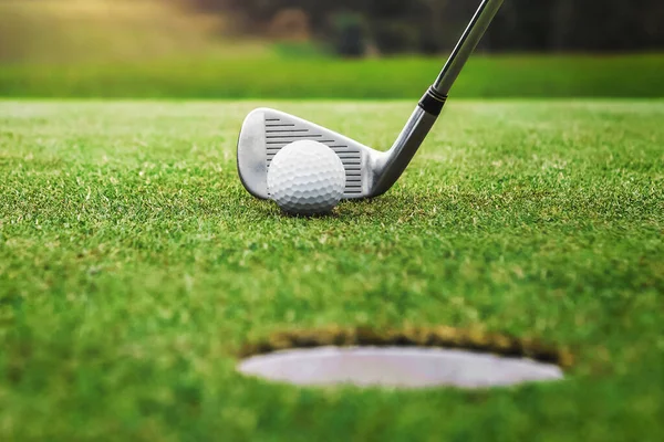 Golf oyuncusu golf topunu deliğe sokuyor