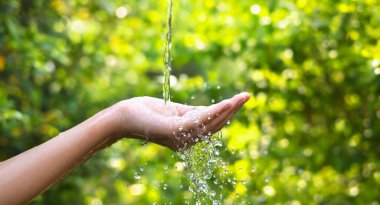 Water pouring on hand in morning ligth background
