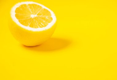limon meyvesi Sarı arka planda sulu bir dilim limon izole edilmiş.