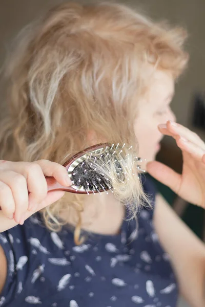 Kämmen mit Bürste und zieht lange Haare. Tägliche Vorbereitung auf das schöne Aussehen. — Stockfoto