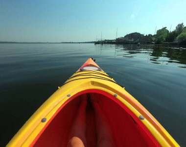Nehirdeki sarı kano. Kanonun önü suyun üzerinde yüzüyor..
