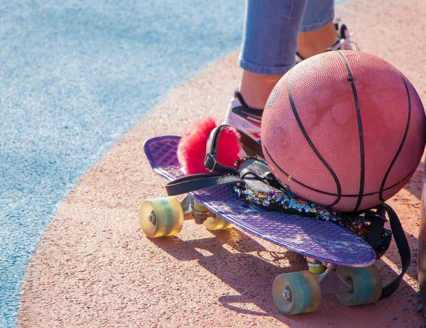 Bola basket terletak pada skateboard anak-anak. Tas tangan perempuan di skateboard — Stok Foto