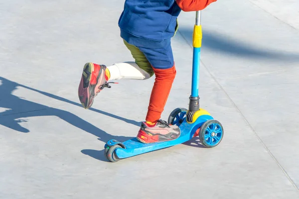 Seorang anak mengendarai scooter Kick. taman bermain untuk naik pada Skuter Kick — Stok Foto
