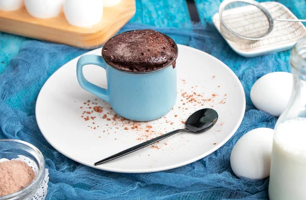 Mugcake is microwaved. Homemade cupcake in a mug is on a plate. — Stock Photo, Image