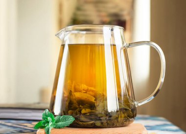 Seçici odaklanma. Tarçın çubukları ve taze naneli çaydanlıkta yeşil çay