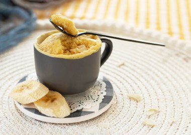 Mini kek. Bardakta kahvaltı mı? Seçici odaklanma. Küçük bardaklarda ev yapımı muzlu mugcake. Mikrodalgada tatlı pişirme fikri, taze muz ve fındıkla. Muz dilimli kek. 