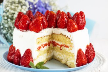 Seçici odaklanma. Bayramlık çilekli pasta. Ev yapımı çilekli pasta kesimi. Taze çilekle süslenmiş çilekli turta tabakta duruyor. Dondurma ve çilekli dondurma. Bir parça kes.. 