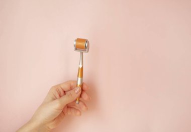 Tıbbi mikro iğne terapisi için deri silindiri. Evde mezoterapi için dermaroller. Pinc arka plan, fotokopi alanı. - Evet. Yüksek kalite fotoğraf