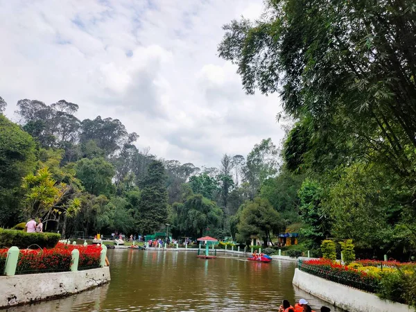 湿地公園内の近代的な都市の建物を背景にボートの人々 — ストック写真