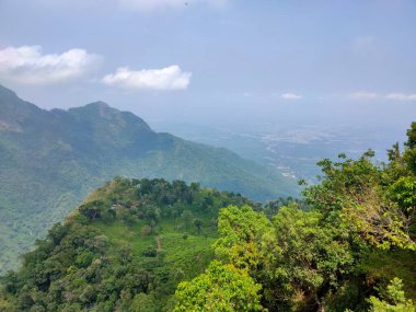 Doğa Sancağı. Dağ manzaralı günbatımı manzaralı pek çok tepe ve yeşil orman manzaralı yumuşak sisli ve renkli gökyüzü