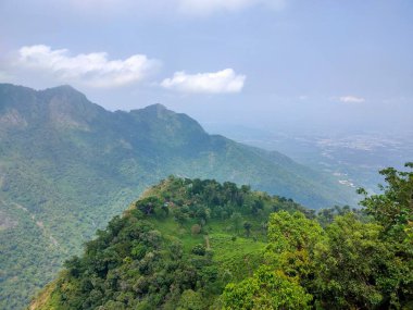 Doğa Sancağı. Dağ manzaralı günbatımı manzaralı pek çok tepe ve yeşil orman manzaralı yumuşak sisli ve renkli gökyüzü