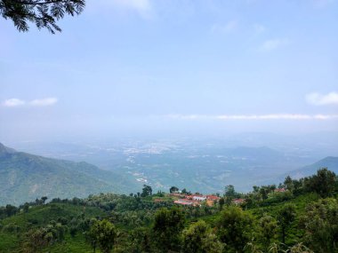 Doğa Sancağı. Dağ manzaralı günbatımı manzaralı pek çok tepe ve yeşil orman manzaralı yumuşak sisli ve renkli gökyüzü