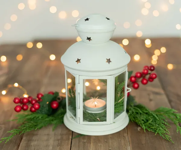 Süslü beyaz fener ve kırsal ahşap masa üzerinde Noel ışıkları. Boşluğu kopyala.